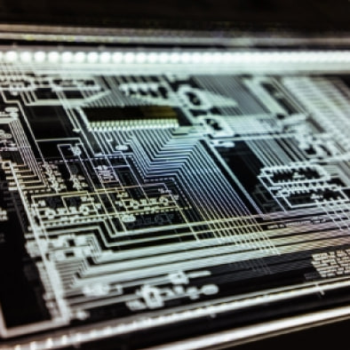Close-up of a circuit board layout glowing on a screen.
